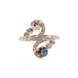 A Sapphire and Diamond Crossover Ring, a round cut sapphire and an old cut diamond to round