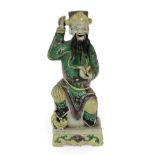 A Chinese Bisque Porcelain Figure of an Immortal, Kangxi, the seated figure wearing a cylindrical