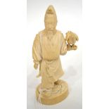 A Japanese Ivory Okimono, Meiji period, as a man standing holding a hawk on his left wrist, on an