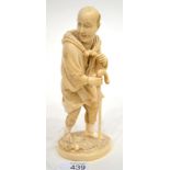 A Japanese Ivory Okimono, Meiji period, as a man holding a bag around his shoulder walking with a