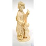A Japanese Ivory Okimono, Meiji period, as a mother and child, she holding a bunch of grapes, a