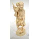 A Japanese Ivory Okimono, Meiji period, as a fisherman standing holding a bird, a further bird at