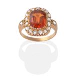 An 18 Carat Gold Hessonite Garnet and Diamond Cluster Ring, a cushion cut hessonite garnet in a