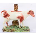 A Large Staffordshire Pottery Cow Spill Vase, early 19th century, the naturalistically modelled