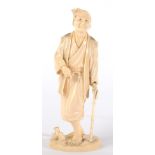 A Japanese Ivory Okimono, Meiji period, as a man standing walking with a stick, signed to red