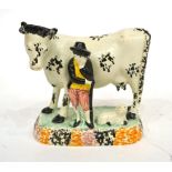 A Yorkshire Pratt Type Pottery Cow Group, circa 1800, the standing beast with black sponged