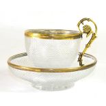 A French Gilt Metal Mounted Cut Glass Coffee Cup and Saucer, 19th century, the leaf sheathed