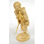 A Japanese Ivory Okimono, Meiji period, as a bearded man holding a bamboo stick and a scroll, on
