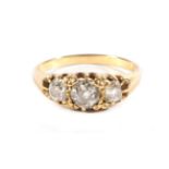 An Old Cut Diamond Three Stone Ring, graduated diamonds in a carved setting, total estimated diamond