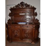 A Victorian Carved Oak Sideboard, 3rd quarter 19th century, the superstructure with two graduated