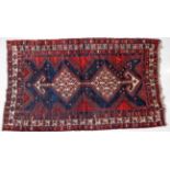 Luri Rug West Iran, circa 1925 The indigo field with twin ivory diamond medallions enclosed by