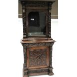A Victorian Carved Oak Bookcase, circa 1880, the bold cornice above an arched glazed door