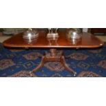 A 19th Century Cross Banded Mahogany Pedestal Dining Table raised on a reeded twist stem and down