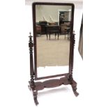 A Victorian Mahogany Cheval Mirror, the rectangular plate with moulded frame, on turned tapering