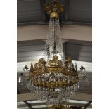 A French Empire Stamped and Gilt Metal and Cut Glass Twenty-Light Electrolier, decorated with angels