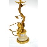 A Gilt Metal Lamp Base, in 18th century style, as a cherub sitting at the base of a tree, on a white