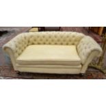 A Chesterfield Two-Seater Drop-End Sofa, upholstered in buttoned yellow floral fabric, the squab