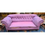 A Victorian Chesterfield Three-Seater Sofa, circa 1880, covered in worn purple fabric with