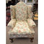 A George III Style Wing-Back Armchair, probably 19th century, recovered in beige floral fabric