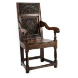 A Joined Oak Wainscot Armchair, the carved back support above nulled uprights and downswept arms,