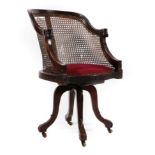 An Edwardian Mahogany and Cane Backed Swivel Chair, early 20th century, the moulded frame and carved