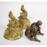 A pair of bronze seated cherubs, modelled writing with stylus on tablet, together with a pair of