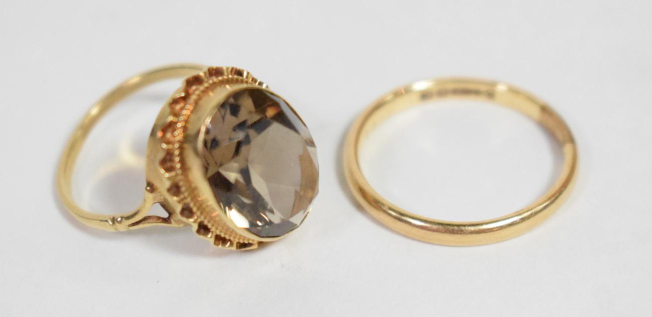 A 9 carat gold band ring, finger size T; a Victorian smokey quartz ring in a yellow metal mount,