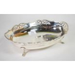 An oval silver basket, maker indistinct, Birmingham 1932, with shaped and pierced rim, on four pad