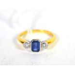 An 18 carat gold sapphire and diamond three stone ring, an emerald cut sapphire spaced by round