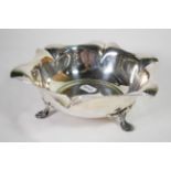 An Art Nouveau silver dish, H Pidduck & Sons, Sheffield 1916, shaped rim, on three stylised hoof