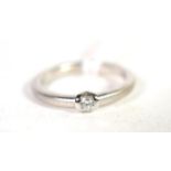 A platinum solitaire diamond ring, a round brilliant cut diamond in a tension setting, to a matte