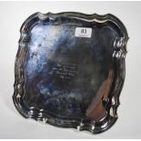 A shaped square silver salver, Harrison Fisher & Co, Sheffiled 1934, on four scroll feet, centre