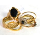 Five 9 carat gold rings including a band ring with pierced decoration, finger size T1/2; an onyx