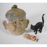 A Wedgwood black basalt cat, with glass eyes; together with a grotesque tobacco jar and a