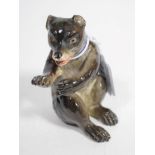 A Meissen porcelain model of a seated bear, 19th century, after the model by J J Kaendler, wearing a