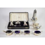 Three various 20th century silver three piece condiment sets, one cased, and a silver clad caster,