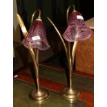 Two decorative brass table lamps with cranberry glass shades, each shade engraved maker's name