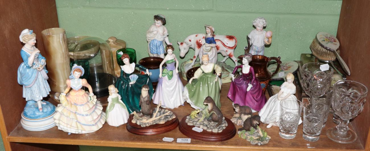 A shelf of decorative ceramics and glass including a pair of bisque figures of hunters;