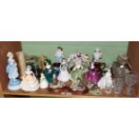 A shelf of decorative ceramics and glass including a pair of bisque figures of hunters;