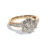 A diamond cluster ring with inset shoulders, stamped '375', finger size H1/2. Gross weight - 2.36