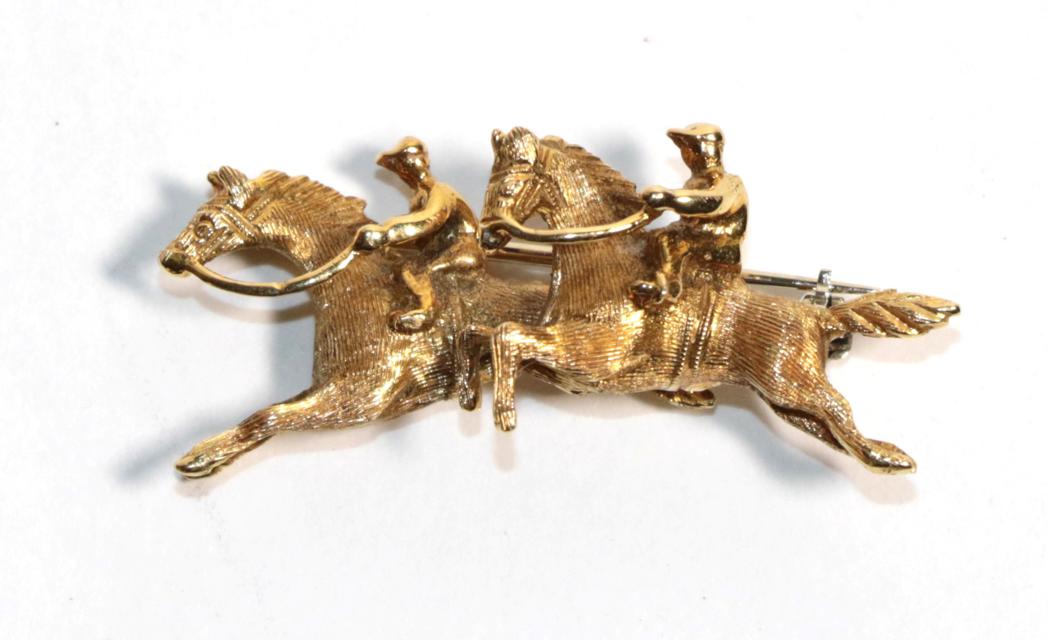 An 18 carat gold brooch modelled as two horses, stamped 'ITALY', length 4cm. Gross weight 6.36