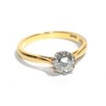 A solitaire diamond ring, a round brilliant cut diamond in white claw setting, to a yellow pointed