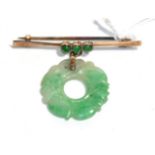 A bar brooch stamped '9ct' with a jade bi-disc suspended, drop measures 3.5cm. Gross weight - 5.02