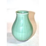 A Chinese Pale Celadon Glazed Porcelain Vase, Qing Dynasty, of fluted baluster form with everted