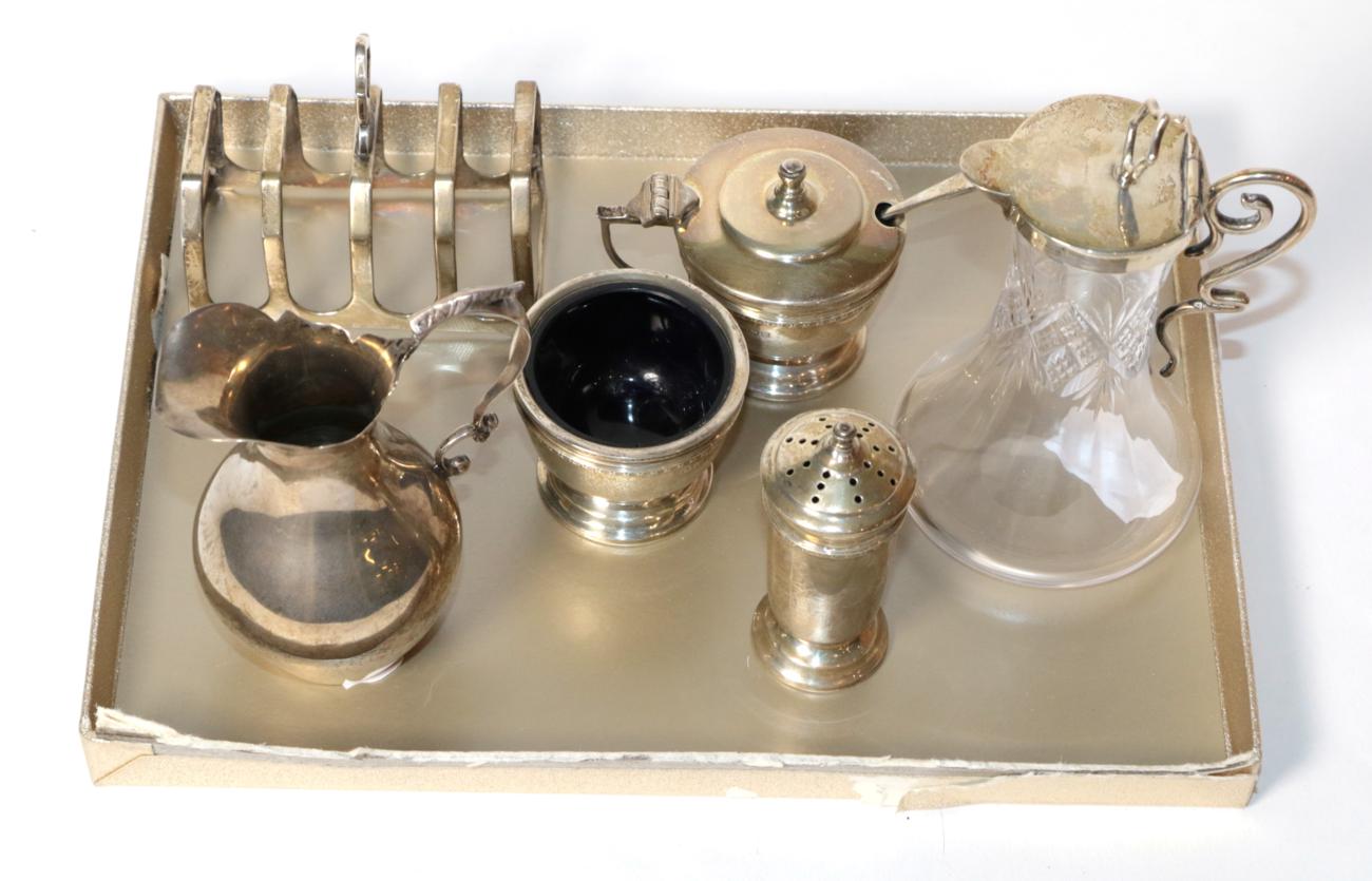 An unusual silver mounted whisky noggin, Birmingham 1903; a toast rack; a condiment set; and a cream