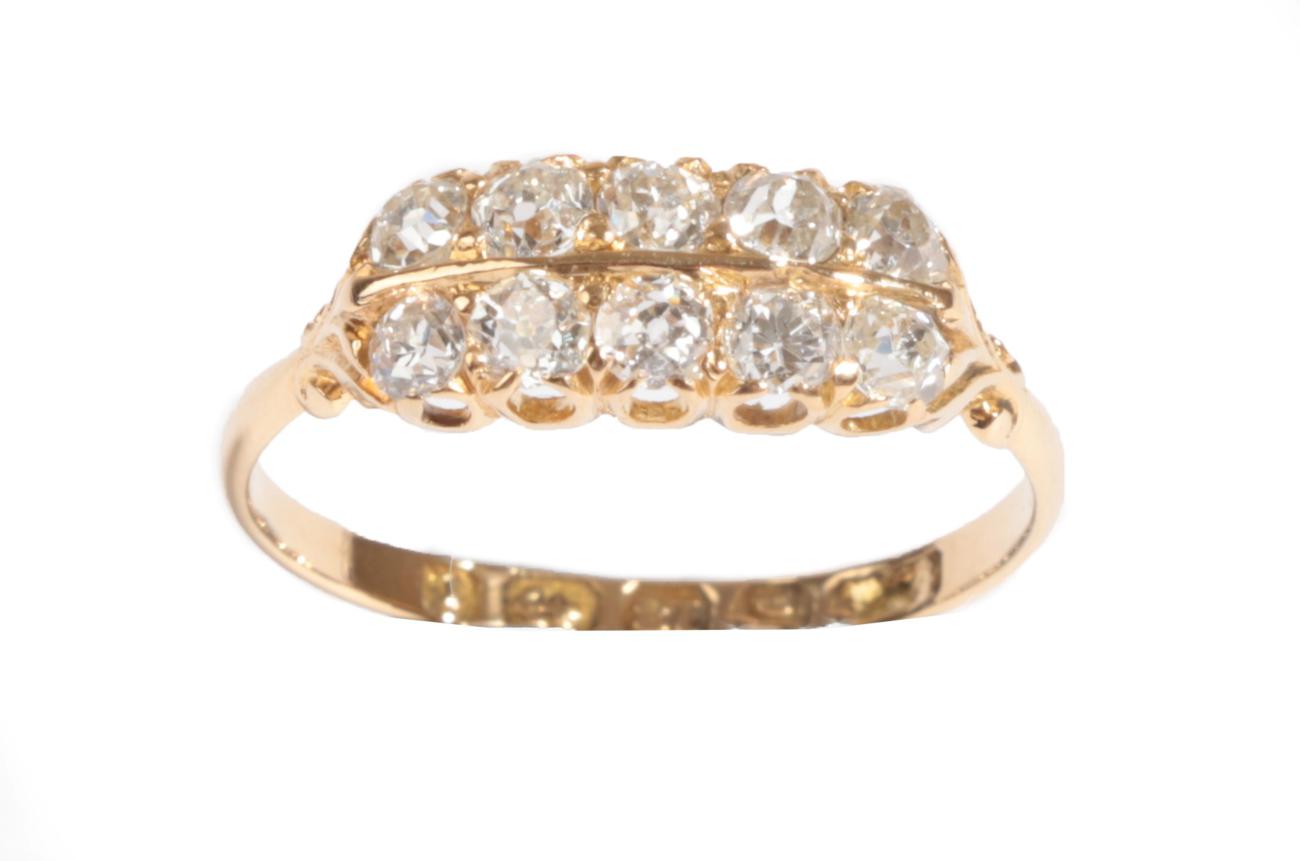 An 18 Carat Gold Diamond Ten Stone Ring, the old cut diamonds in two rows, in yellow claw