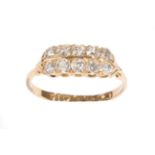 An 18 Carat Gold Diamond Ten Stone Ring, the old cut diamonds in two rows, in yellow claw