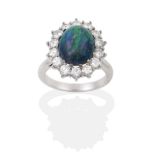 A Black Opal and Diamond Cluster Ring, the oval cabochon opal within a border of fourteen round