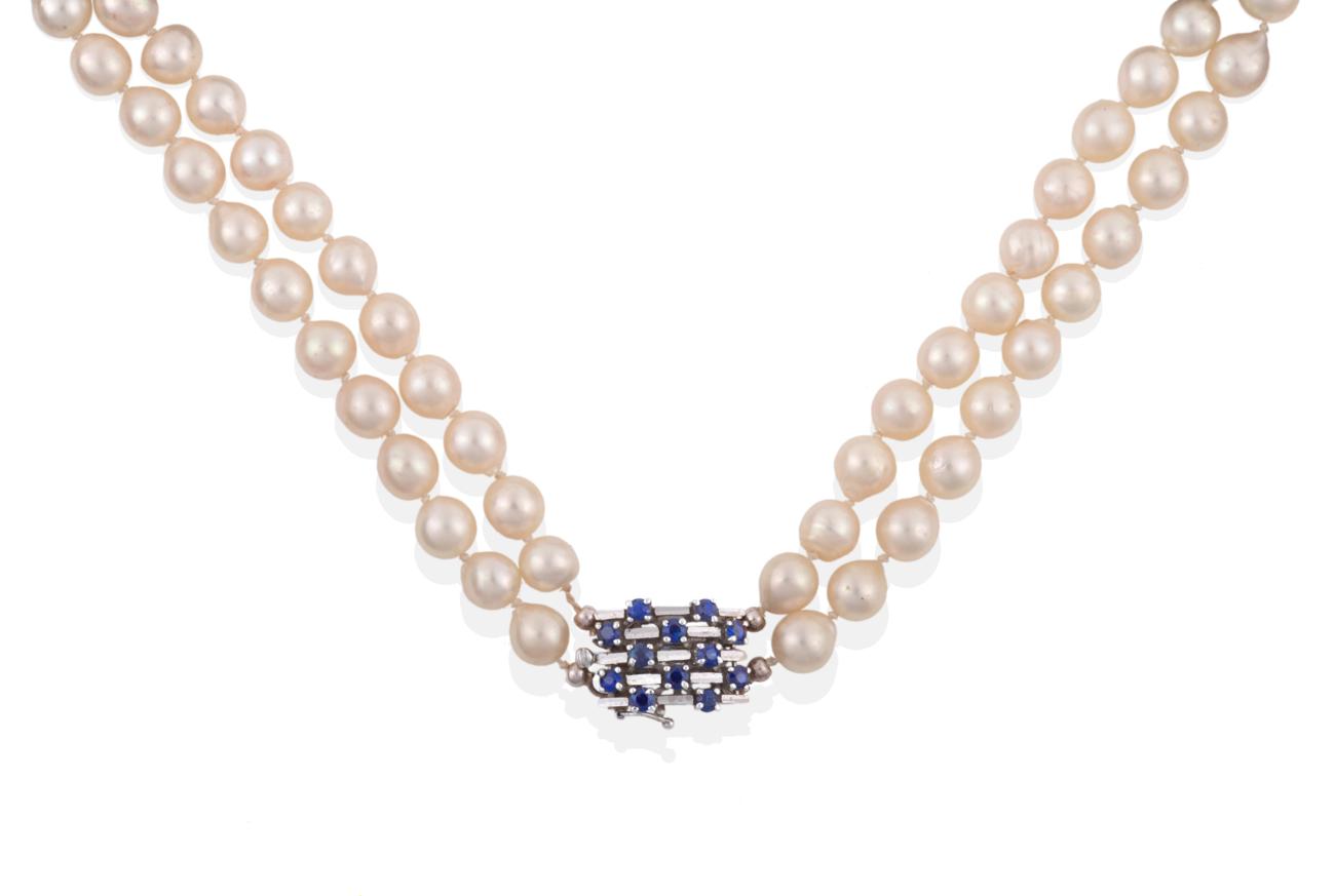 A Two Row Cultured Pearl Necklace, the 45:49 pearls knotted to an oblong clasp set with sapphires in