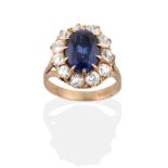 A Synthetic Sapphire and Diamond Cluster Ring, an oval cut synthetic sapphire in a claw setting,